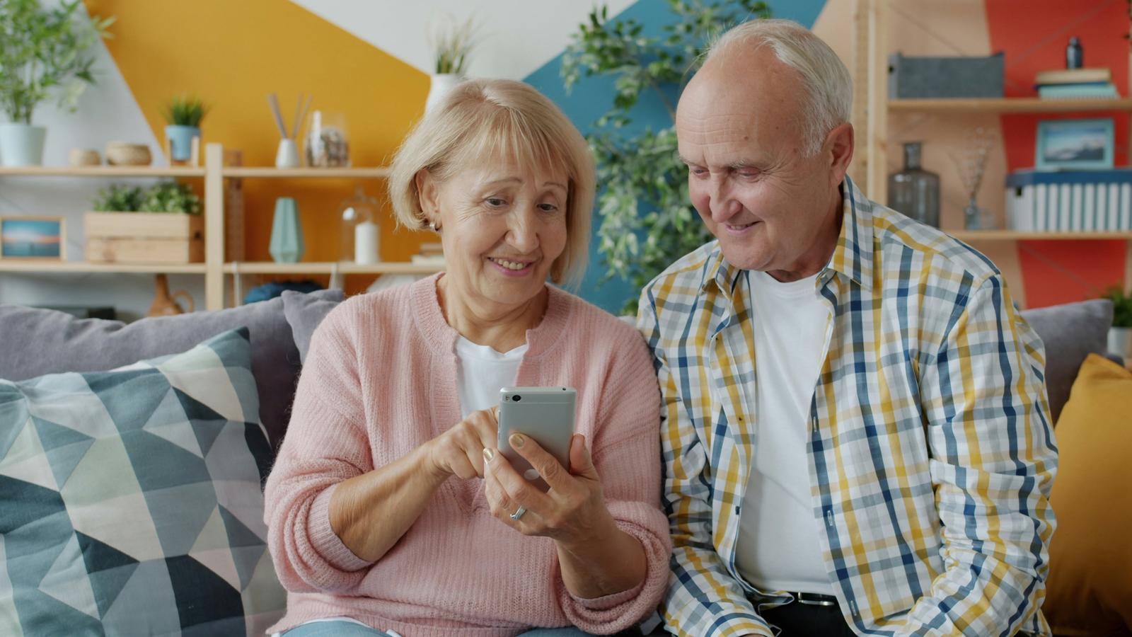 Elderly couple looking at phone together